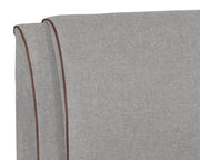 Lit muni d'une tête de lit magnifiquement rembourrée en tissu gris chiné et bordures contrastantes